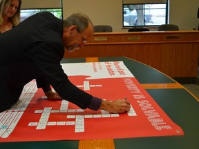 Stony Plain deputy mayor Russ Graff signs on to the United Way’s campaign to end poverty on Sept. 12 at town hall. - Thomas Miller, Reporter/Examiner