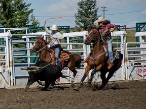 The Zur sisters, Britnie (left) and Abby (right) compete in the team roping contest at their hometown high school rodeo on Saturday, Sept. 13, 2014. John Stoesser photos/QMI Agency.