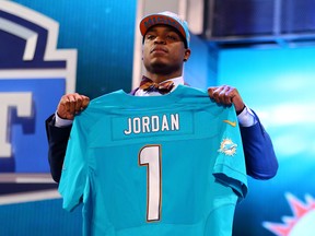 Dion Jordan of the Oregon Ducks holds up a jersey on stage after he was picked #3 overall by the Miami Dolphins. (Al Bello/Getty Images/AFP)