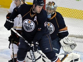 Edmonton Oilers' Ryan Whitney (C) and goalie Nikolai Khabibulin (R) check Anaheim Ducks' Brandon McMillan. (REUTERS/Dan Riedlhuber)