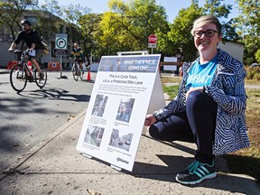 Amanda Gelinas, a senior transportation engineer with the City of Edmonton, poses next to a sign describing the use of bike lines along the proposed bike lane near 105 Street and 83 Avenue in Edmonton, Alta., on Friday, Sept. 19, 2014. Codie McLachlan/Edmonton Sun/QMI Agency