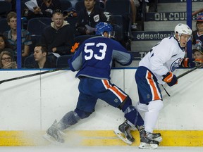 Edmonton Oilers forward Mitch Moroz (53) checks Jordan Oesterle (82) during a scrimmage at training camp at Rexall Place in Edmonton, Alta., on Friday, Sept. 19, 2014. The NHL hockey team conducted drills and played a scrimmage. Ian Kucerak/Edmonton Sun/ QMI Agency