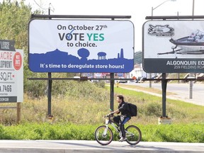 Gino Donato/The Sudbury Star
A cyclist rides past a sign, located on The Kingsway, supporting deregulating store hours in Sudbury. Sudburians will vote on the issue Oct. 27.