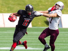 Carleton Ravens WR Nathaniel Behar straight-arms Ottawa U Gee-Gees Mike Randazzo during play in the Panda Game on Saturday September 20, 2014. Errol McGihon/Ottawa Sun/QMI Agency