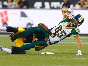 Eskimos’ Nate Coehoorn catches a pass against Tiger-Cats’ Courtney Stephen in Hamilton last night. The Ticats are now 3-0 in their new home. (Mark Blinch/Reuters)