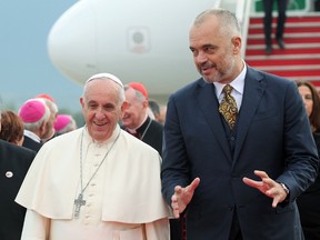 Pope Francis speaks with Albania's Prime Minister Edi Rama (R) at Mother Teresa airport in Tirana September 21, 2014. Pope Francis is on a one-day trip to Albania - his first to a European country - to pay tribute to followers of all religions who suffered some of the worst persecution in the 20th century, and to hold up the impoverished nation as a model of inter-religious harmony.  REUTERS/Pool