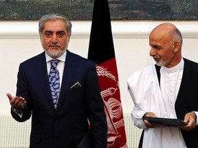 Afghan rival presidential candidates Abdullah Abdullah (L) and Ashraf Ghani stand together after exchanging signed agreements for the country's unity government in Kabul September 21, 2014. Abdullah and Ghani signed a deal to share power in the unity government on Sunday, capping months of turmoil over a disputed election that destabilised the nation at a crucial time as foreign troops prepare to leave. Ashraf Ghani, a former finance minister, will be named president under the deal reached on Saturday night.  REUTERS/Omar Sobhani