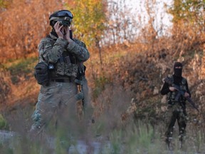 Ukrainian servicemen secure the area during an exchange of prisoners-of-war (POWs) near Donetsk, eastern Ukraine, September 20, 2014. The two sides, that of the government forces and the pro-Russian separatists, are exchanging POWs under the terms of the current ceasefire. REUTERS/David Mdzinarishvili