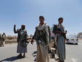 Shi'ite Houthi rebels man a checkpoint they set up along a street in Sanaa September 21, 2014. Shi'ite Houthi rebels and government forces fought for a fourth straight day in the Yemeni capital, residents said, despite the announcement of a U.N.-brokered agreement due to be signed later on Sunday. REUTERS/Khaled Abdullah