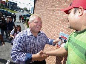 Mayoral candidate Doug Ford shakes hands with Jacob D'Souza (R) as he finally kicked off his campaign going door-to-door up Kipling Ave on Saturday, September 20, 2014. (Jack Boland/Toronto Sun)