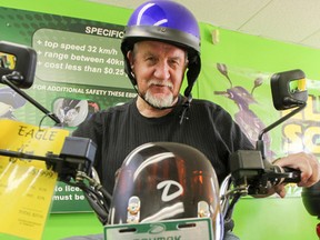 Bill Taylor, owner of The Electric Scooter Store, poses on one of the e-bikes models that can be found on the streets of Kingston. (Julia McKay/The Whig-Standard)