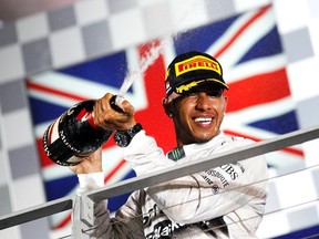 Lewis Hamilton sprays champagne on the podium following the Singapore F-1 Grand Prix at the Marina Bay street circuit in Singapore on Sunday. (Reuters)