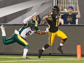 Hamilton Tiger-Cats Brandon Banks (R) scores a touchdown past Edmonton Eskimos Alonzo Lawrence during the second half of their CFL football in Hamilton, September 20, 2014.    REUTERS/Mark Blinch (CANADA - Tags: SPORT FOOTBALL)
