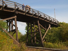 Reinhart Gauss, David Winter, Nicole Winter and Donna Szpakowski stand on the historic timber bridge. (MIKE HENSEN, The London Free Press)