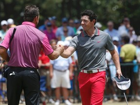 Rory McIlroy (R), of Northern Ireland, congratulates compatriot Graeme McDowell after finishing on the 18th green during the first round of the U.S. Open Championship golf tournament in Pinehurst, North Carolina, June 12, 2014. (REUTERS)