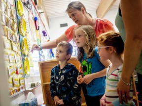 Michele Plamondon, points to a photo on a wall of, while her son Aubrey and daughter Avery looks on in one of the kindergarten classrooms in Pat Hardy Primary school in Whitecourt, on Wednesday, Sept. 17. Aubrey is starting kindergarten at Pat Hardy this year.