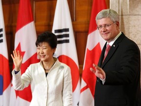 Prime Minister Stephen Harper, right, and South Korea's President Park Geun-hye wave at the conclusion of a news conference on Parliament Hill in Ottawa September 22, 2014. (REUTERS/Chris Wattie)