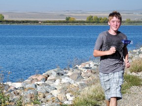 Adam Prentice, a Grade 8 student at Milo School, takes part in the annual Terry Fox Run as he makes his way back across the Lake McGregor dam.