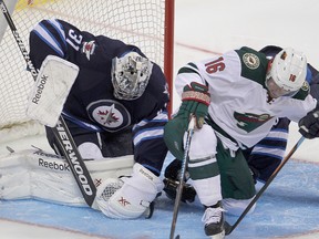 Winnipeg Jets goalie Ondrej Pavelec (l) stops a shot by Minnesota Wild forward Jason Zucker during NHL hockey in Winnipeg, Man. Monday, September 22, 2014.
Brian Donogh/Winnipeg Sun/QMI Agency