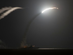 The guided-missile cruiser USS Philippine Sea (CG 58) launches a Tomahawk cruise missile, as seen from the aircraft carrier USS George H.W. Bush (CVN 77), in the Arabian Gulf in this handout photograph taken and provided on September 23, 2014. REUTERS/Mass Communication Specialist 1st Class Eric Garst/U.S. Navy/Handout