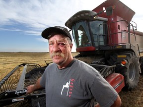 Norm Scott bears the wounds from an encounter with a truck thief as he combines a filed of wheat ion his farm east of Penhold , Alta., on Monday September 22, 2014. Mike Drew/Calgary Sun/QMI Agency