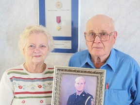 Evelyn and Gord Garrett of Odessa hold a portrait of their son Const. Chris Garrett, who was killed in the line of duty 10 years ago in Cobourg. A bridge over Hwy. 401 is to be dedicated to his memory Thursday.
(Elliot Ferguson/The Whig-Standard)
