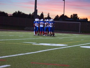 The Mustangs offence huddles up as the sun sets in the second quarter of their game against the Chinook Coyotes. Greg Cowan photo/QMI Agency.