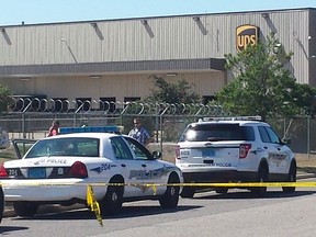 Police vehicles are seen outside a UPS service center following a deadly shooting in Birmingham, Alabama September 23, 2014.  A recently-fired UPS employee on Tuesday shot dead two supervisors at the company facility where he had worked in Birmingham, Alabama before turning the gun on himself, police said.  REUTERS/Sherrel Wheeler Stewart
