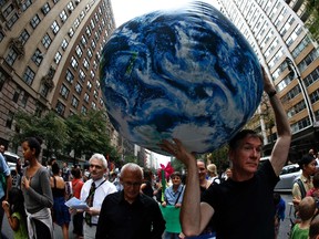 A man carries an inflatable earth balloon along West 72nd Street during the People's Climate March in New York, September 21, 2014. An international day of action on climate change brought hundreds of thousands of people onto the streets of New York City on Sunday, easily exceeding organizers' hopes for the largest protest on the issue in history. Organizers estimated that some 310,000 people, including United Nations Secretary-General Ban Ki-moon, former U.S. Vice President Al Gore, actor Leonardo DiCaprio and elected officials from the United States and abroad joined the People's Climate March, ahead of Tuesday's United Nations hosted summit in the city to discuss reducing carbon emissions that threaten the environment.  REUTERS/Mike Segar   (UNITED STATES - Tags: POLITICS CIVIL UNREST