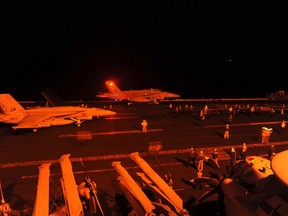 An F/A-18E Super Hornet, attached to Strike Fighter Squadron (VFA) 31, and an F/A-18F Super Hornet, attached to Strike Fighter Squadron (VFA) 213, prepare to launch from the flight deck of the aircraft carrier USS George H.W. Bush (CVN 77) to conduct strike missions against ISIL targets, in the Arabian Gulf in this U.S. Navy handout photograph provided September 23, 2014. United Kingdom Prime Minister David Cameron said on Wednesday he wanted Britain to join U.S.-led air strikes against the Islamic State. /REUTERS/U.S. Navy/Mass Communication Specialist 3rd Class Robert Burck/Handout via Reuters