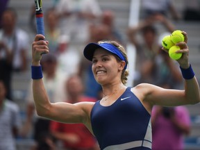 Eugenie Bouchard of Canada prepares to hit balls into the crowd after her quarterfinal win over Alize Cornet of France at the Wuhan Open tennis tournament in Wuhan, in China's Hubei province on September 25, 2014.  (AFP PHOTO/Greg BAKER)