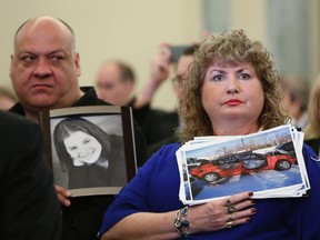 Mary Theresa Ruddy, right, whose daughter Kelly was killed in 2010 when she lost control of her 2005 Chevrolet Cobalt, holds a picture of the vehicle, while her husband Leo, left, holds a photo of their daughter at a Senate Commerce and Transportation Consumer Protection, Product Safety and Insurance subcommittee hearing in Washington, in this April 2, 2014 file photo. (REUTERS/Gary Cameron/Files)