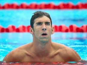 Michael Phelps of the US reacts following the men's 100 m butterfly heat at the Gold Coast Aquatic Centre. (AFP PHOTO / PATRICK HAMILTON)
