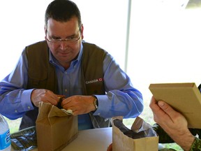 Minister of International Development Christian Paradis opens his ration bag during a lunch time visit to Roxas, Philippines, on Tuesday November 26, 2013. (Gavin John/QMI Agency)