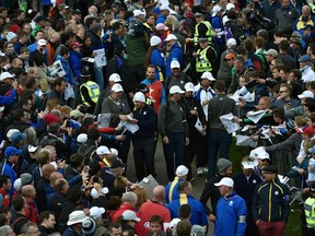Players sign autographs as they walk between the eighth and ninth hole during practice ahead of the 2014 Ryder Cup at Gleneagles in Scotland September 25, 2014. (REUTERS/Toby Melville)