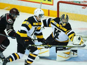 Kingston Frontenacs goalie Lucas Peressini makes a glove save against  Peterborough Petes'  Eric Cornel as defenceman Jarkko Parikka looks on during first-period OHL action on Thursday at the Memorial Centre in Peterborough. (Clifford Skarstedt/QMI Agency)
