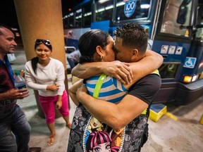 Cuban migrant Mailin Perez embraces with her husband Jose Caballero after arriving via Mexico at a bus station in Austin, Texas September 25, 2014.  Almost a year after he smuggled his way out of Cuba on a homemade boat, Caballero was reunited late Thursday with his wife who survived a harrowing sea voyage of her own last month. 
REUTERS/Ashley Landis