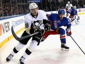 Beau Bennett #19 of the Pittsburgh Penguins and Raphael Diaz #4 of the New York Rangers keep their eye on the puck. (Bruce Bennett/Getty Images/AFP)