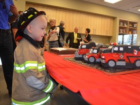 Liam Brown checks out the fire truck cakes after the Acheson Fire Hall was officially opened. His brother, Ryan Brown, is a volunteer firefighter. - April Hudson, Reporter/Examiner