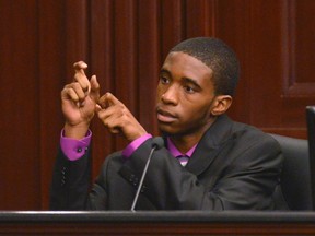 Witness Leland Brunson shows how Michael Dunn pulled back the slide on his weapon as he testifies in Dunn's first-degree murder trial in Jacksonville, Florida February 7, 2014. (REUTERS/Bob Mack/The Florida Times-Union/Pool)