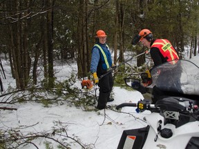 Dieter Eberhardt, left, and Scott Buckley, trail co-ordinator and president of the Lennox and Addington Ridge Runners snowmobile club, were among the volunteers who spent three days and over 100 man-hours clearing debris and trees that had fallen along the local snowmobile trails due to the ice storm in December 2013.