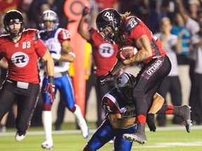 Ottawa RedBlacks Jonathan Williams eludes the tackle of Montreal Alouettes Chip Cox on his way to scoring a TD during CFL action at TD Place on Friday September 26, 2014. Errol McGihon/Ottawa Sun/QMI Agency