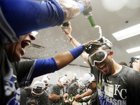 Royals first baseman Eric Hosmer (right) celebrates with champagne in the clubhouse after defeating the White Sox to clinch an American League wild card playoff berth in Chicago on Friday, Sept. 26, 2014. (Jerry Lai/USA TODAY Sports)