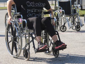 Team member Courtney Smith, of Rebels with a Cause, competes in a wheelchair relay at Standing Oaks care home Saturday. This year's Race to Erase fundraiser attracted 43 teams who raised more than $39,000. BARBARA SIMPSON/THE OBSERVER/QMI AGENCY