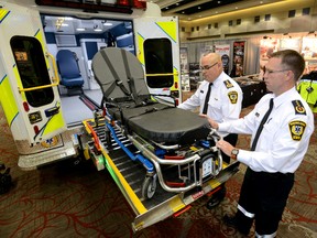 Chris Darby, left, and Steve Cook, both operations superintendents with London-Middlesex Emergency Medical Services, demonstrate a hydraulic lift on their new special operations vehicle. The lift will be used to transport patients weighing more than 500 lbs. MORRIS LAMONT / THE LONDON FREE PRESS / QMI AGENC