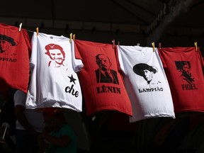 Shirts with images of Lampiao, Che Guevara, Lenin and Fidel Castro are displayed in front of a gym where the opening ceremony of the 6th National Congress of the Landless Workers Movement (MST) is being held in Brasilia February 10, 2014. REUTERS/Ueslei Marcelino