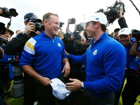 Team Europe golfer Jamie Donaldson (L) celebrates with teammate Rory McIlroy after winning his match against U.S. player Keegan Bradley to retain the Ryder Cup for Europe on the 15th green during the 40th Ryder Cup at Gleneagles in Scotland September 28, 2014. (REUTERS/Eddie Keogh)