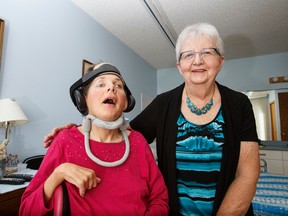 Cheryl and Barbara Kersh pose for a photo in their home in St. Albert, Alta., on Saturday, Sept. 20, 2014. Cheryl was severely injured in a car crash in 1982 putting her in a wheelchair, changing both women's lives. Ian Kucerak/Edmonton Sun/ QMI Agency