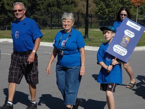 Carl Chute, left, of St. Thomas walks with Anne Walker and her grandson Braden Saturday at Believe in a Cure Walk for ALS. The trio walked in memory of Walker's husband Ron, who died from ALS in 2010. 

Ben Forrest/Times-Journal