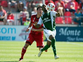 Toronto FC midfielder Daniel Lovitz (35) battles for a ball with Portland Timbers forward/midfielder Darlington Nagbe (6) during the second half in a game at BMO Field on Sept. 27. (USA Today Sports)